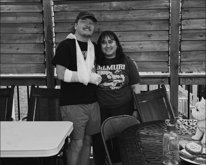 Alex M. on a deck with his arm in a cast and sling.