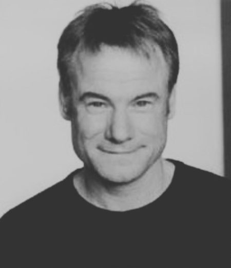 A stock headshot of a smiling man, not Logan.